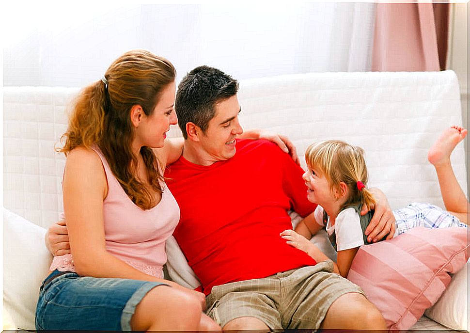 Parents talking to their daughter on the couch about coping with adversity.