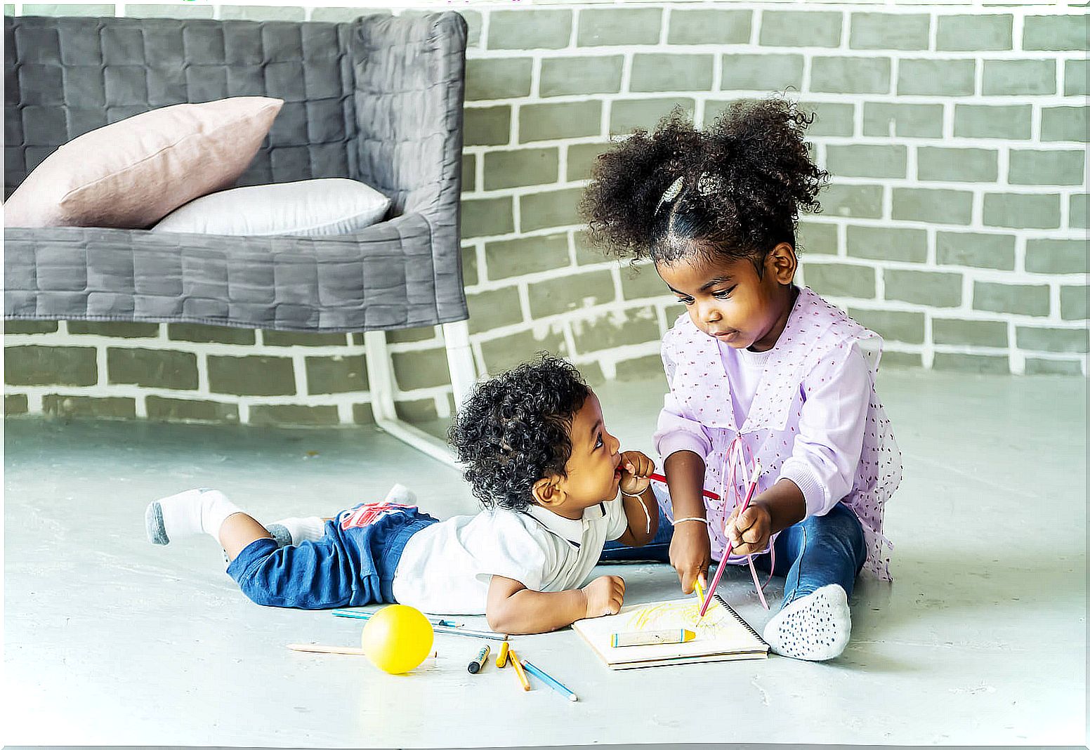 Sibling children doing crafts at home.