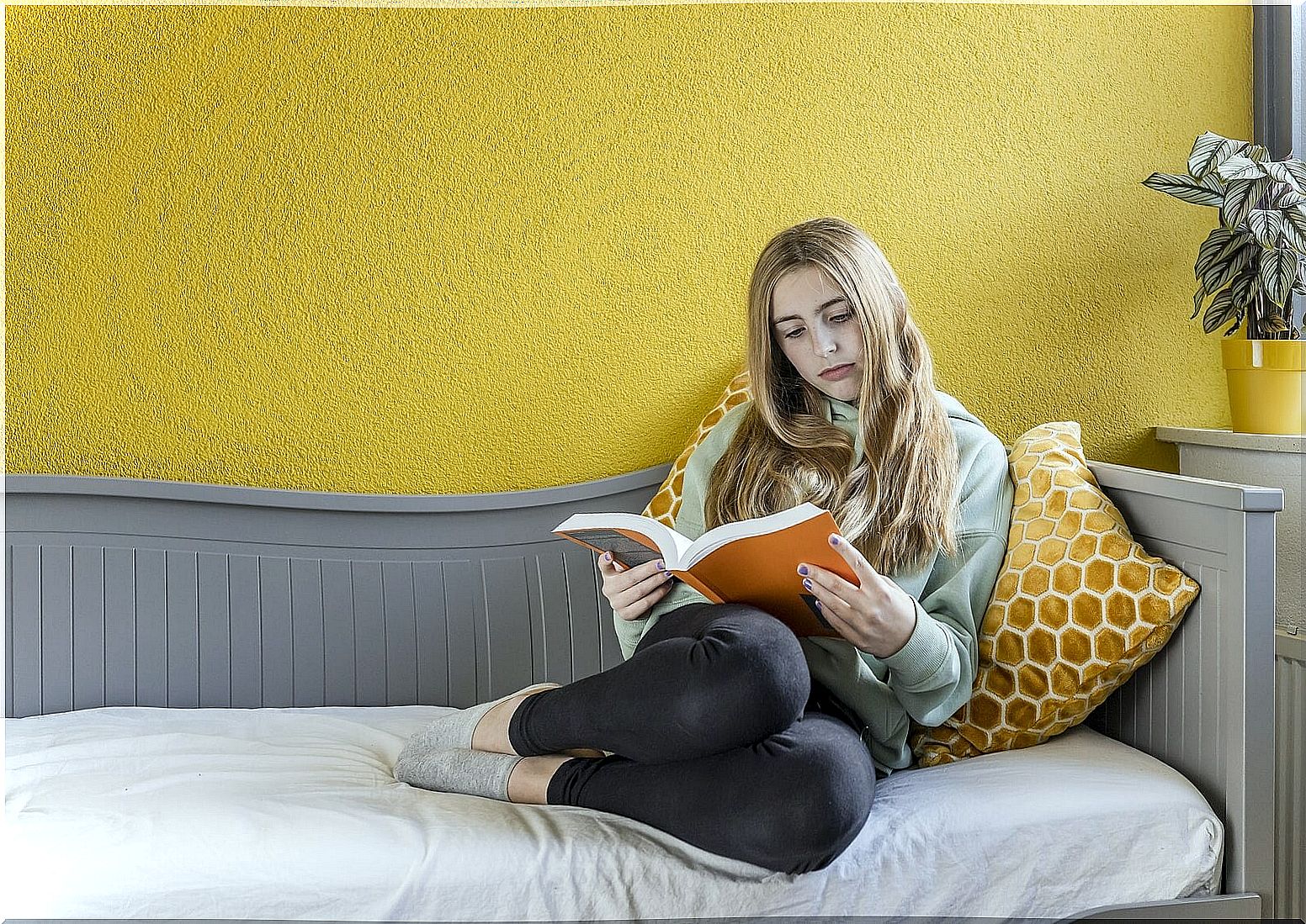 Girl placidly reading authors that teenagers really like.