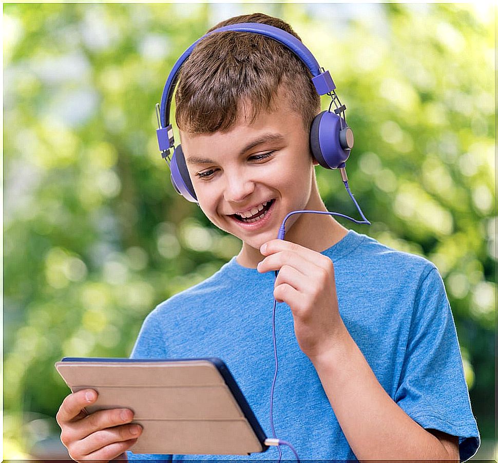 Child talking with the tablet to review the contents of the course in summer.