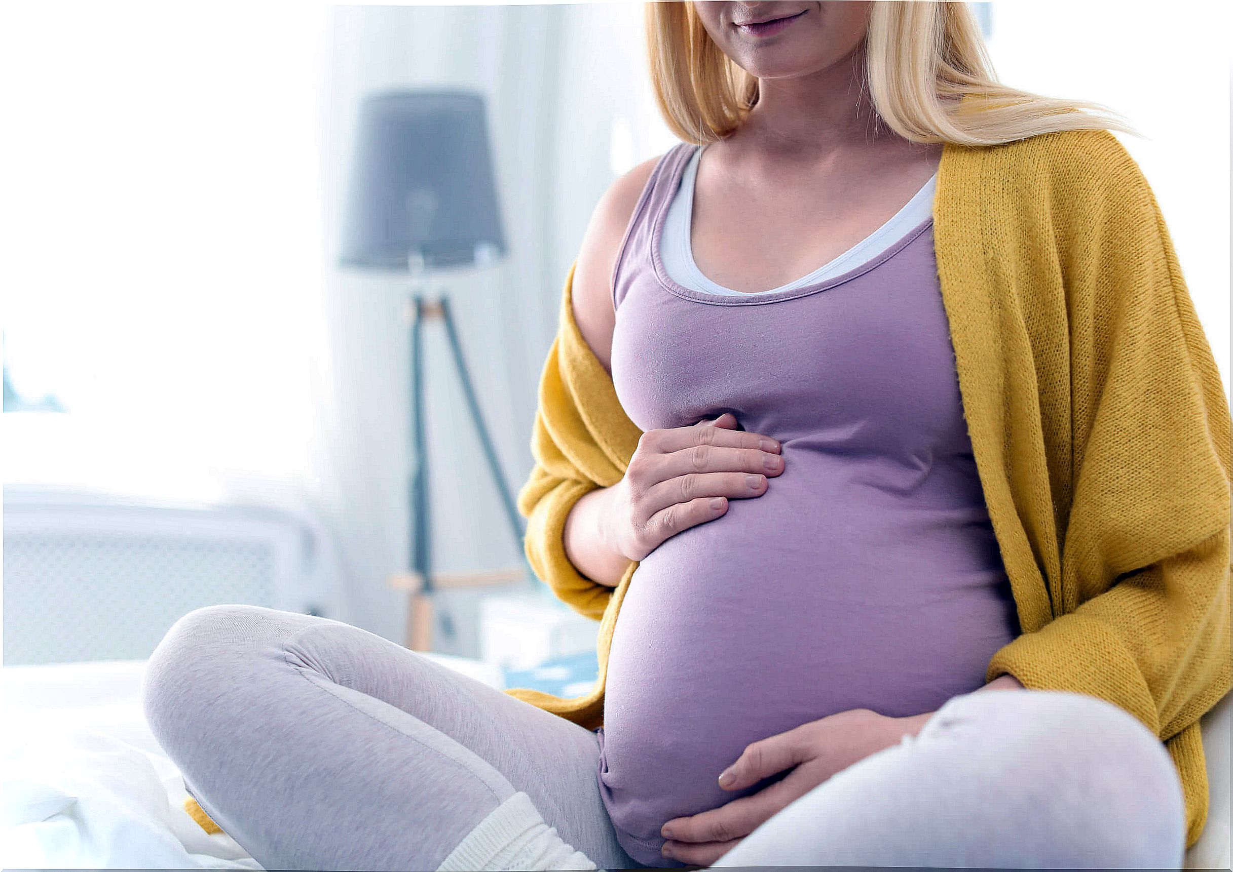 Pregnant woman stroking her tummy.