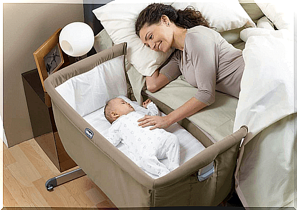 Mother with her baby in her cot co-sleeping