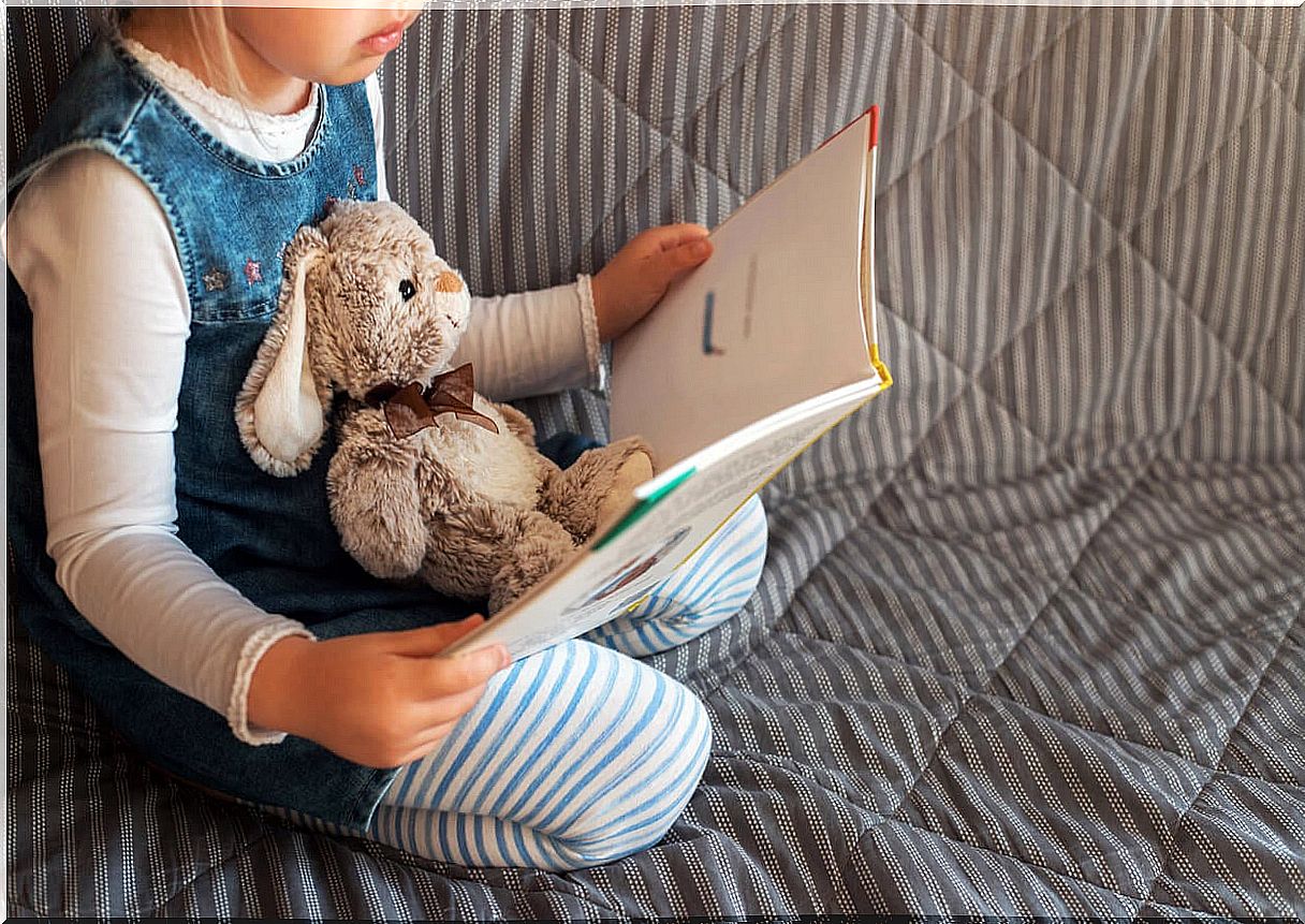 Girl reading a story her stuffed rabbit for International Children's Book Day.