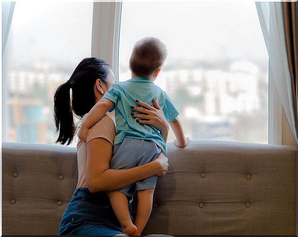 Mother and son looking out the window during the coronavirus quarantine.