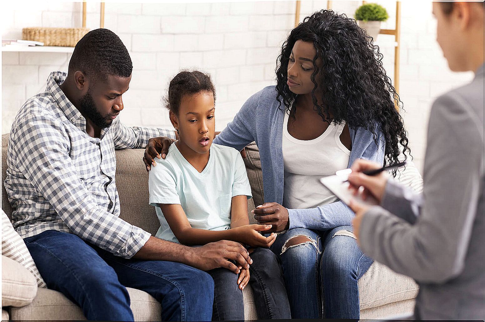 Parents with their daughter in emotional therapy.