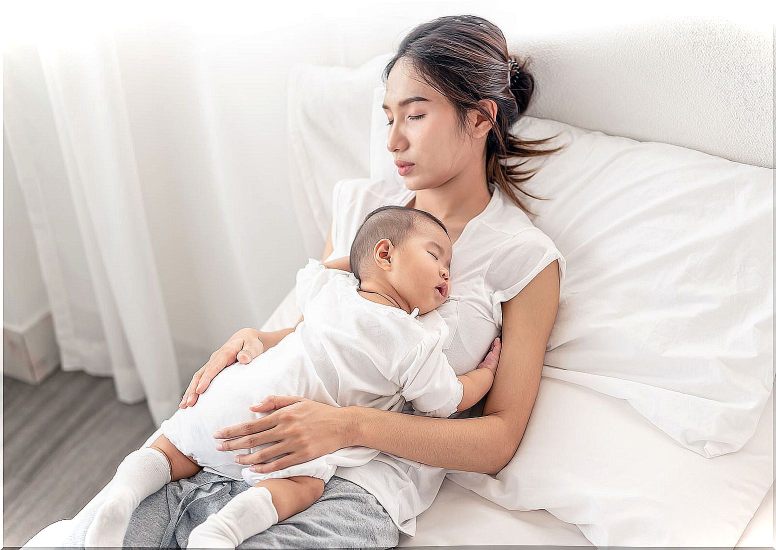 Mother with her sleeping baby in her arms.