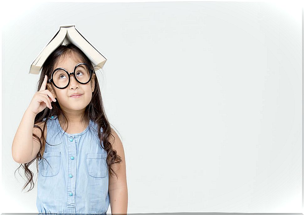 Little girl with a book on her head improving her critical thinking.