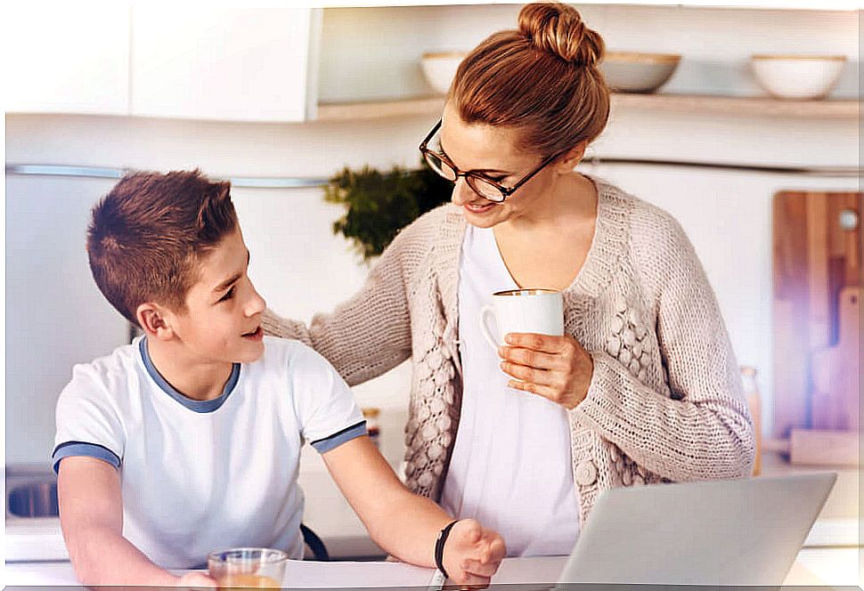 Mother talking to her teenage son over a coffee hand in hand.