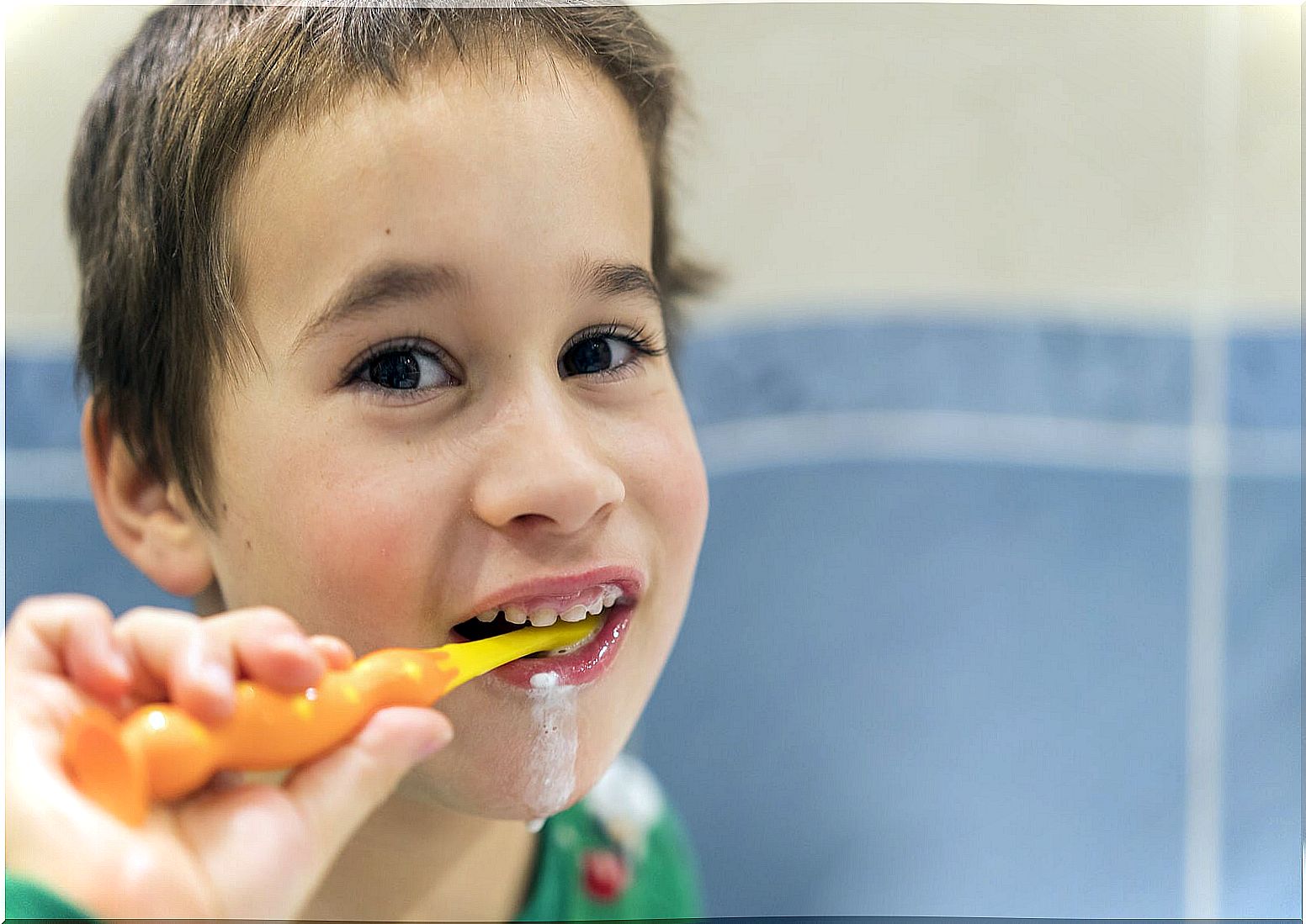 Child brushing teeth with fluoride paste.