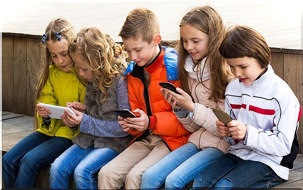 Children looking at electronic screens, both mobile phones and tablets.