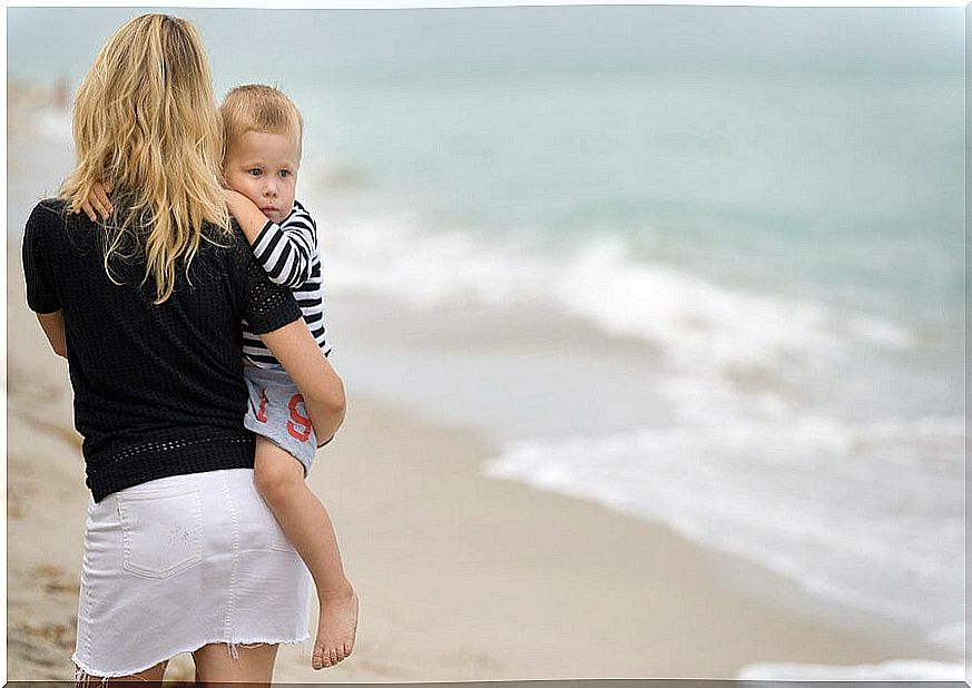 Mother with her son enjoying a cloudy day at the beach.