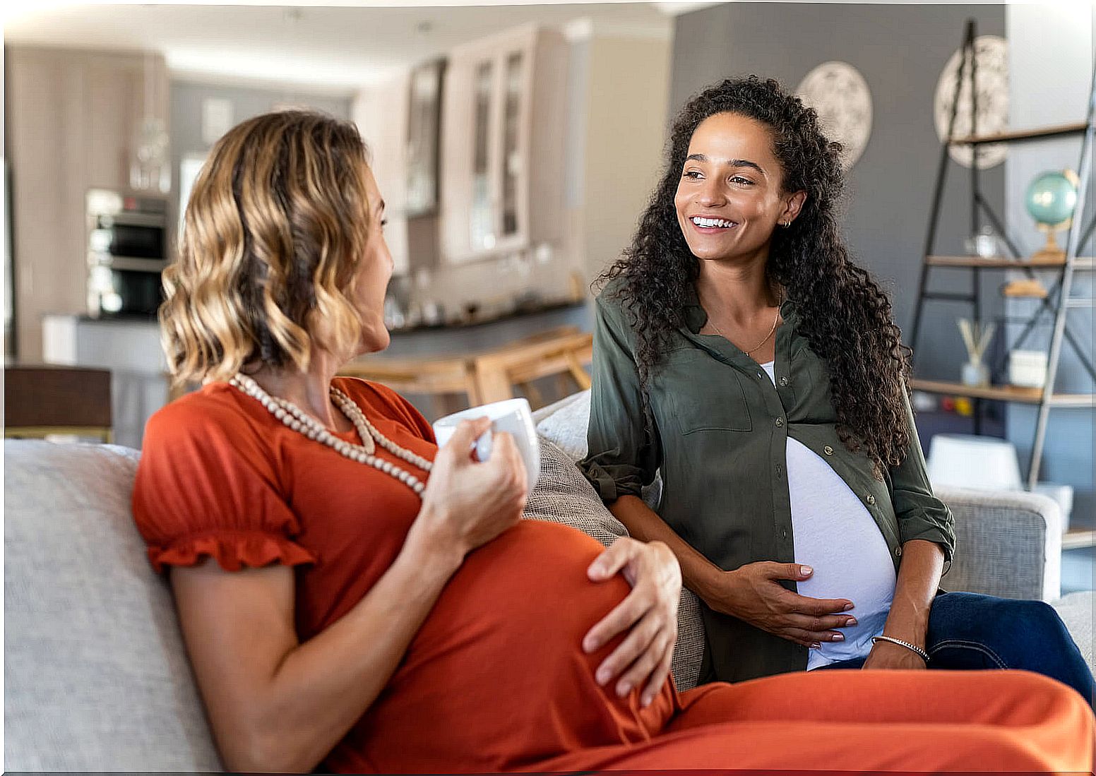 Pregnant women chatting while having a drink.