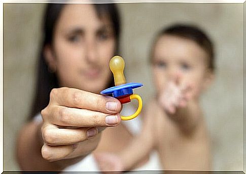 Mother holding her son's pacifier.